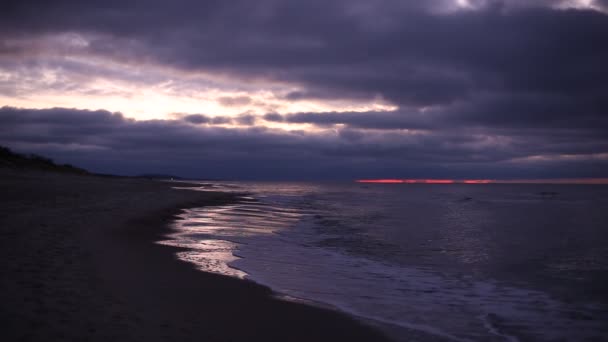 Inverno frio ventoso mar Báltico costa praia em crepúsculo luz roxa com céu nublado dramático e ondas românticas tranquilas. Uma filmagem de vídeo HD com áudio — Vídeo de Stock