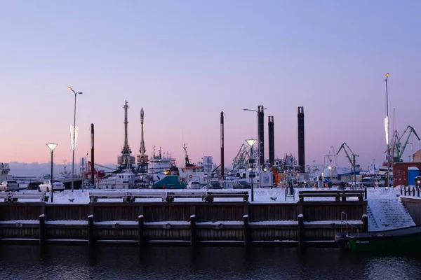 Klaipeda, Lituania - 14 de enero de 2021. Construcciones portuarias industriales cubiertas de nieve. Cielo frío rosa y azul. — Foto de Stock