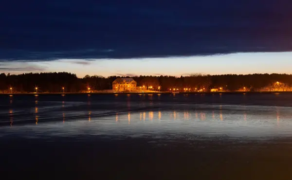 Město Klaipeda, Litva v lednu. A starý historický hotel na druhé straně uronské laguny a zlatého světla v noci — Stock fotografie