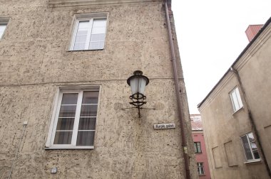 Litvanyaca 'dan çeviri: Pencereli ve eski bir fenerli Sanstone House cephesinin bir parçası. Litrhuania Klaipeda şehrinin sokak manzarası.