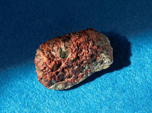 Granát z almandinového kamene uvnitř skály. Minerál izolovaný na modrém pozadí. Nalezeno poblíž Miass City, Ural, Rusko. Geologie mineralogie webové stránky, sbírka kamenů katalog atd — Stock fotografie