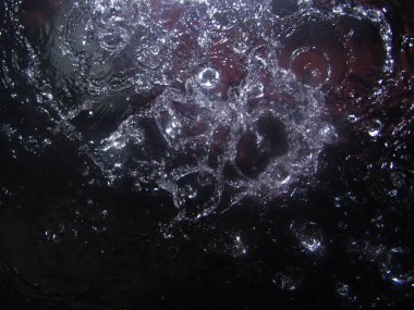 Güçlü bir su püskürtüsü cama çarpar ve üzerine yayılır.