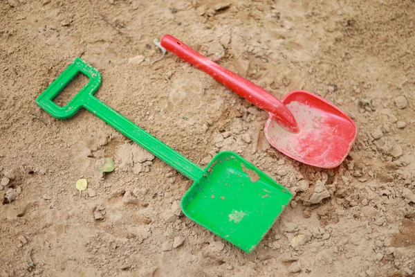 Red Green Kids Toddlers Plastic Play Shovels Laying Sandbox Sand — Stock Photo, Image