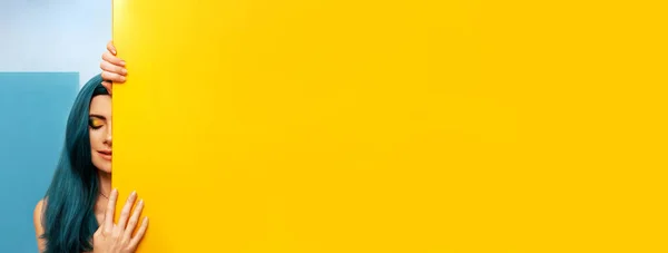 Geometrik arka planda parlak mavi saçlı seksi bir kadının olduğu moda sarı pankart. Moda makyajı. Güzel portre..