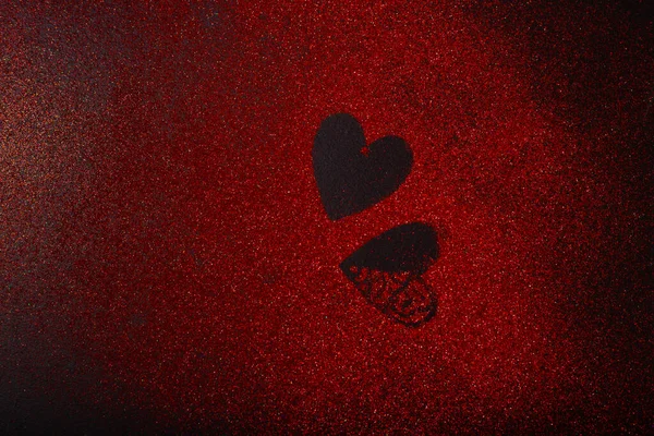 Two heart shapes among red glitter sparkles shaped — Stock Photo, Image