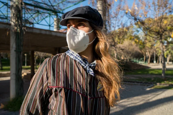 Gün batımında parkta maskeli bir kız.