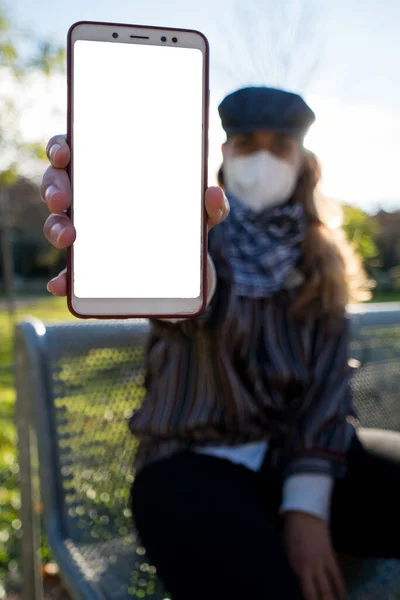 Kız kameraya cep telefonunu gösteriyor..