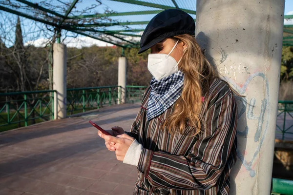 Mädchen Mit Maske Schaut Aufs Handy — Stockfoto