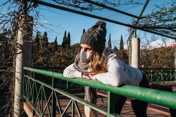Gün batımına bakan maskeli kız.