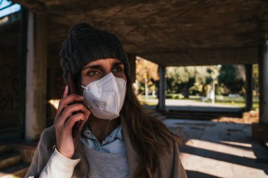 Parkta telefonda konuşan şapkalı kız..