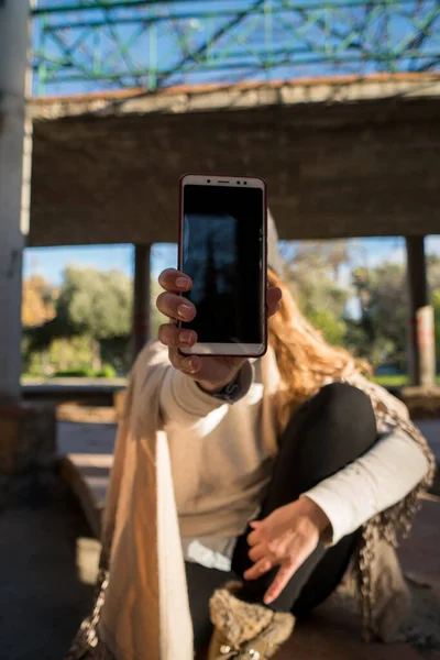 Kameraya cep telefonunu gösteren kız..