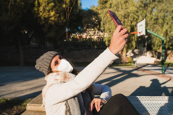 Maskeli kız parkta selfie çekiyor..