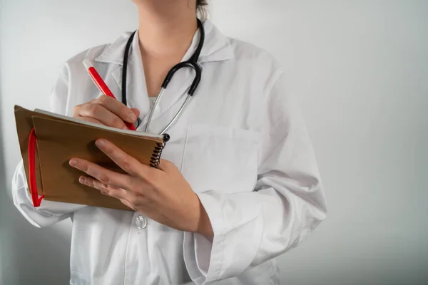 Hastanede elinde kalem ve defter olan bir doktor var..