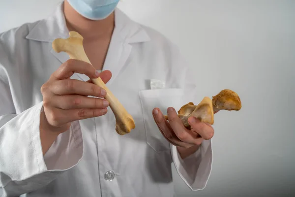 Klinikteki kemikleri araştıran maskeli bir doktor..