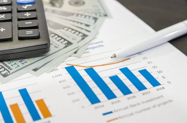 İş grafikleri ve grafikleri kalem ve hesap makinesiyle mali müşavirin masasında. Finansal soyut kavramlar.