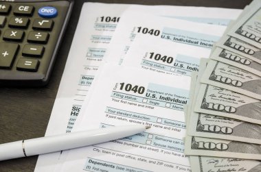 Vergi formları 1040 dolar, not defteri, hesap makinesi ve kalem. Finansal belge. Vergi kavramı.