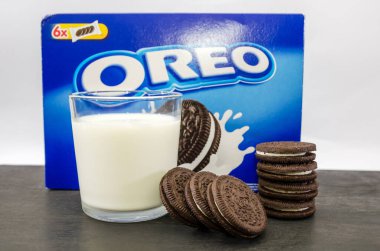 Kiev, Ukrayna-22 Ekim 2020: Çikolata kaplı bir paket Oreo kurabiyesi ve beyaz arka planda bir bardak süt, süt ve kurabiye