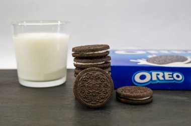 Kiev, Ukrayna-22 Ekim 2020: Çikolata kaplı bir paket Oreo kurabiyesi ve beyaz arka planda bir bardak süt, süt ve kurabiye