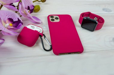 Modern akıllı saat, akıllı telefon ve kulaklık beyaz arka planda bir çantada. Aksesuarlı kadın akıllı telefonu..