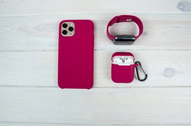 Modern akıllı saat, akıllı telefon ve kulaklık beyaz arka planda bir çantada. Aksesuarlı kadın akıllı telefonu..