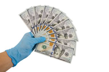 Mavi eldivenli eller beyaz arka planda izole edilmiş dolarları tutar..