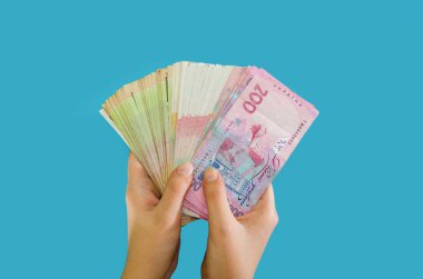 Ukrayna 'nın parası mavi ellerde izole edilmiş kadınların elinde. Finansal konsept. Yeni banknotlar.