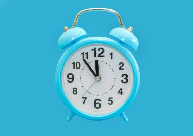Mavi arka planda mavi alarm saati var. Alarm saati 23.55. Neredeyse gece yarısı..