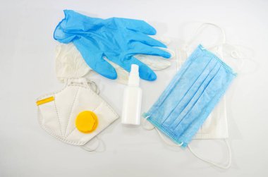 Tıbbi maskeler, eldivenler, beyaz bir arka planda antiseptik şişesi. Coronavirus koruma kavramı.