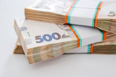 Beyaz arkaplanda üç deste Hryvnia yakın plan.