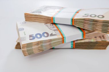 Beyaz arkaplanda üç deste Hryvnia yakın plan.