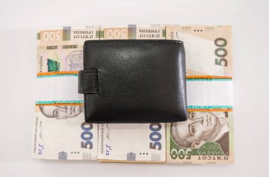 Beyaz arka planda bir deste hryvnias ve siyah bir adamın cüzdanı..