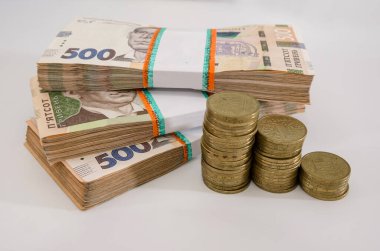 Ukrayna Hryvnia 'sı ve beyaz arka planda yığınla bozuk para. Paketlerdeki yazı 