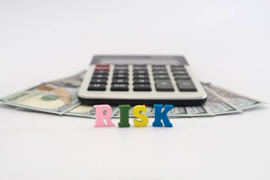 Dolar, hesap makinesi ve beyaz arkaplandaki renkli harflerden çıkan 