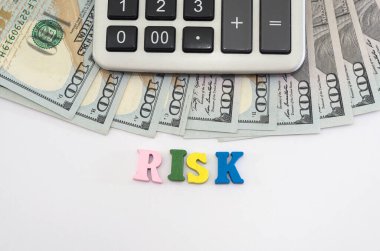 Dolar, hesap makinesi ve beyaz arkaplandaki renkli harflerden çıkan 