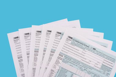 Vergi konsepti. Mavi arka planda Amerikan vergi formları. Nisan 'da doldurulacak 1040 form. Vergi zamanı