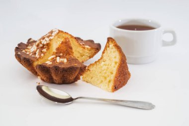 Lezzetli kremalı kek ve beyaz arka planda bir fincan çay..