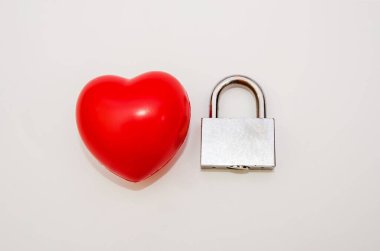 Beyaz arka planda kırmızı kalp ve metal asma kilit. Sevgililer Günü konsepti.