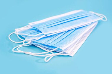 Mavi arka planda birden fazla tıbbi maske