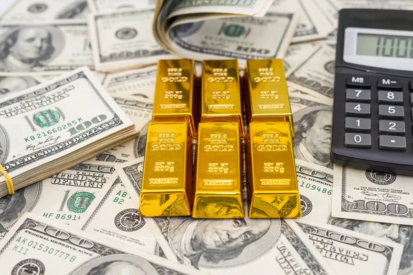 gold bars and calculator on 100 new US dollar banknotes. business and finance concept
