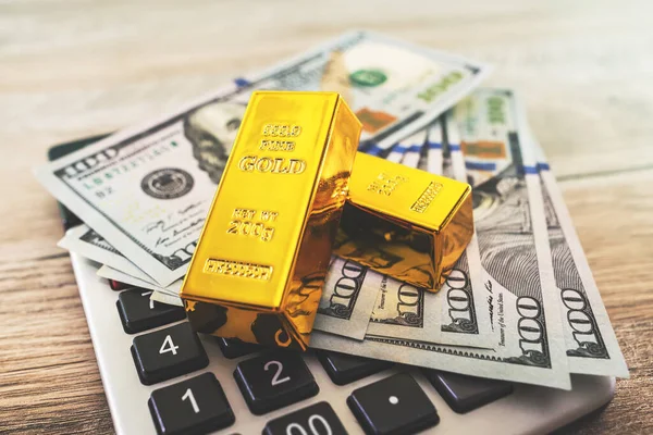 gold bars with calculator and dollars. Financial savings concept.