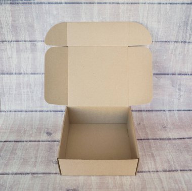 Tahta bir arka planda karton kutu aç.