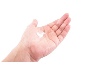 Beyaz arka planda izole bir kadın elinde beyaz krem. El bakımı konsepti