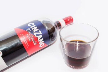 Kiev, Ukrayna - 24 Nisan 2021: Beyaz arka planda izole edilmiş bir şişe İtalyan Cinzano Rosso vermut ve cam. Yakın plan..