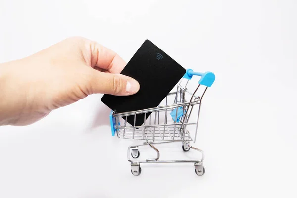 Πιστωτική Κάρτα Στο Χέρι Και Ένα Τρόλεϊ Για Ψώνια Λευκό — Φωτογραφία Αρχείου