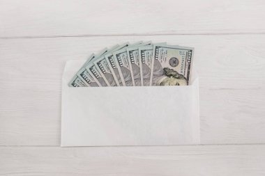 Beyaz ahşap arka planda bir zarfın içinde dolar. Düz yatıyordu.
