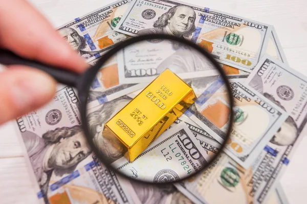 Золотой Слиток Долларах Увеличительным Стеклом Рука Лупой Проверяет Золотой Слиток — стоковое фото