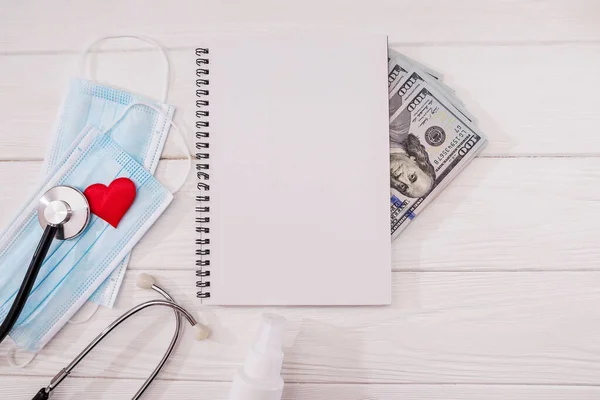 Medical Masks Heart Stethoscope Notepad Dollars White Wooden Background — Stock Photo, Image