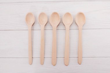 Tahtaların üzerinde tahta kaşıklar. Beyaz arkaplanda boş kaşıklar.