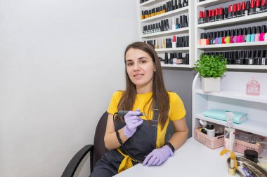 Kuaförde elektrikli ojeli kadın ustası. Donanım manikürü. El bakımı kavramı.