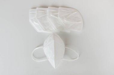 Beyaz arka planda beyaz tıbbi maskeler. Yukarıdan görüntüle.